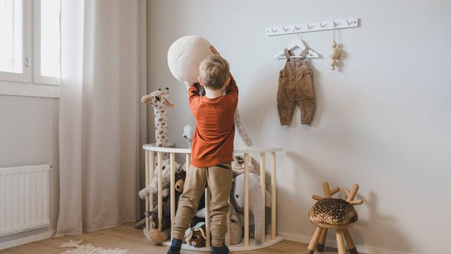 Toddler climbing on play furniture in a nursery