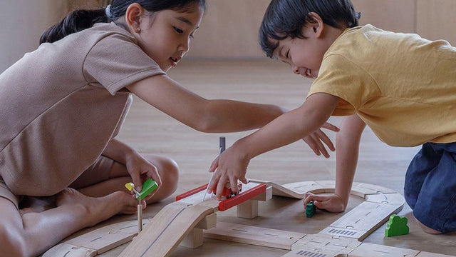 Children playing with toy cars and vehicles on the floor