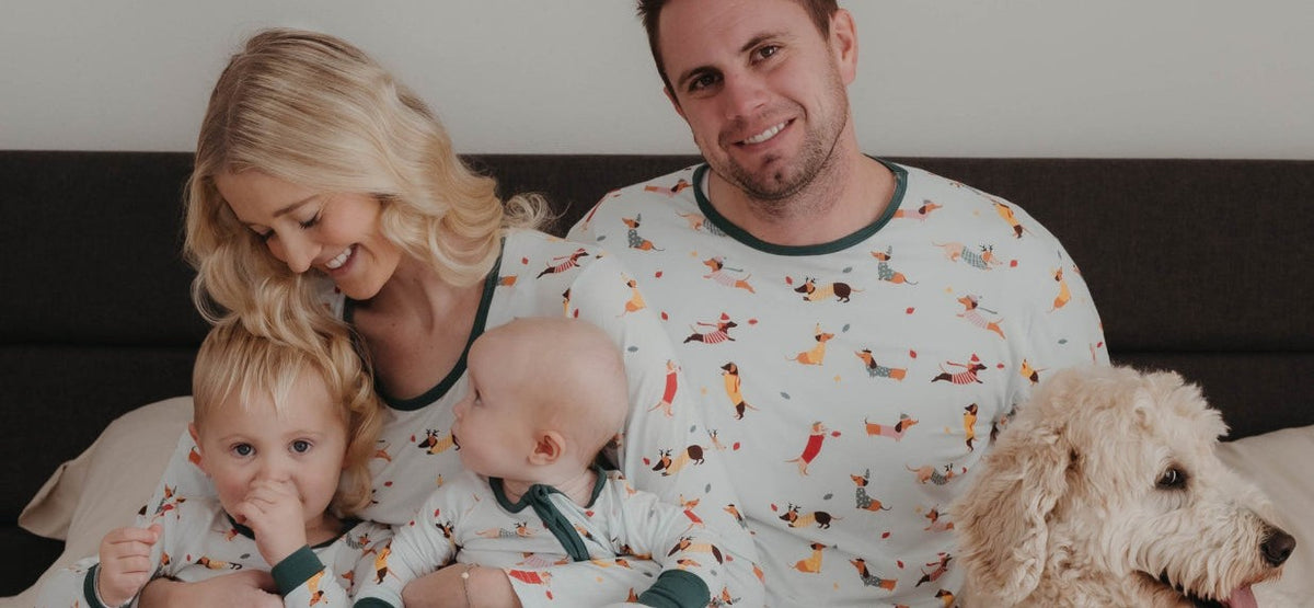 Family in matching holiday pajamas with their dog