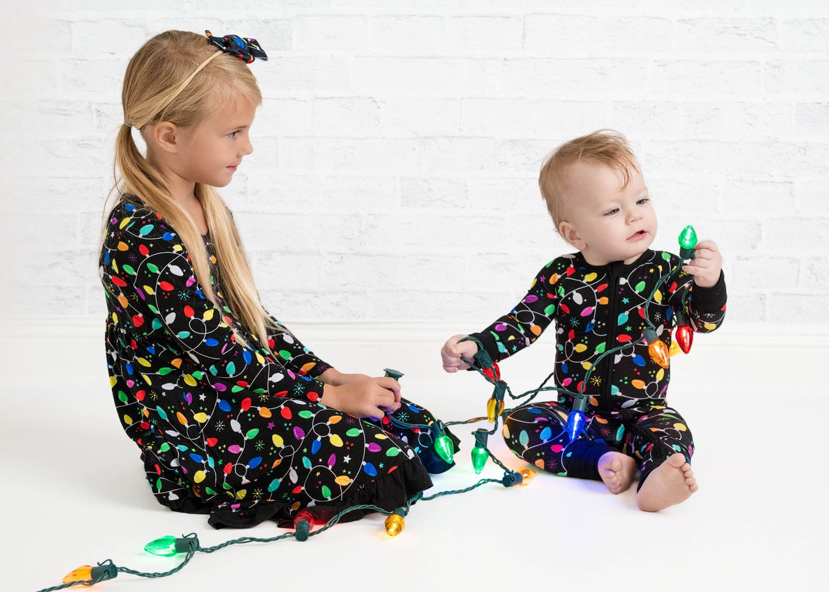 Kids in matching holiday-lights Christmas pajamas