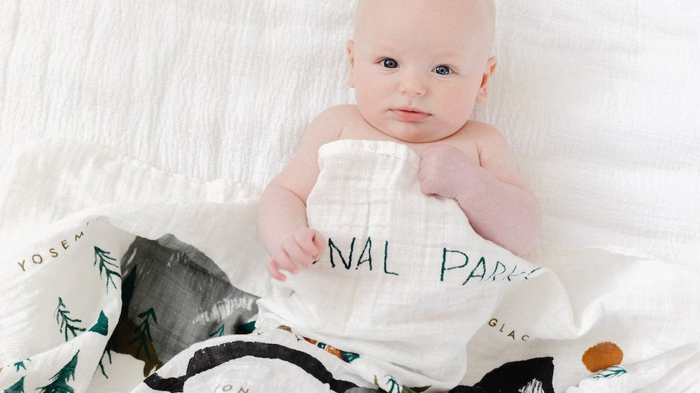 Baby swaddled in a printed muslin sleep sack