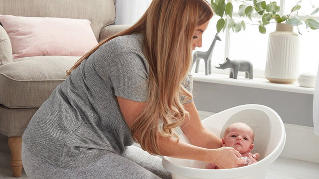 Parent bathing a baby