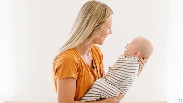 Parent settling a baby at bedtime