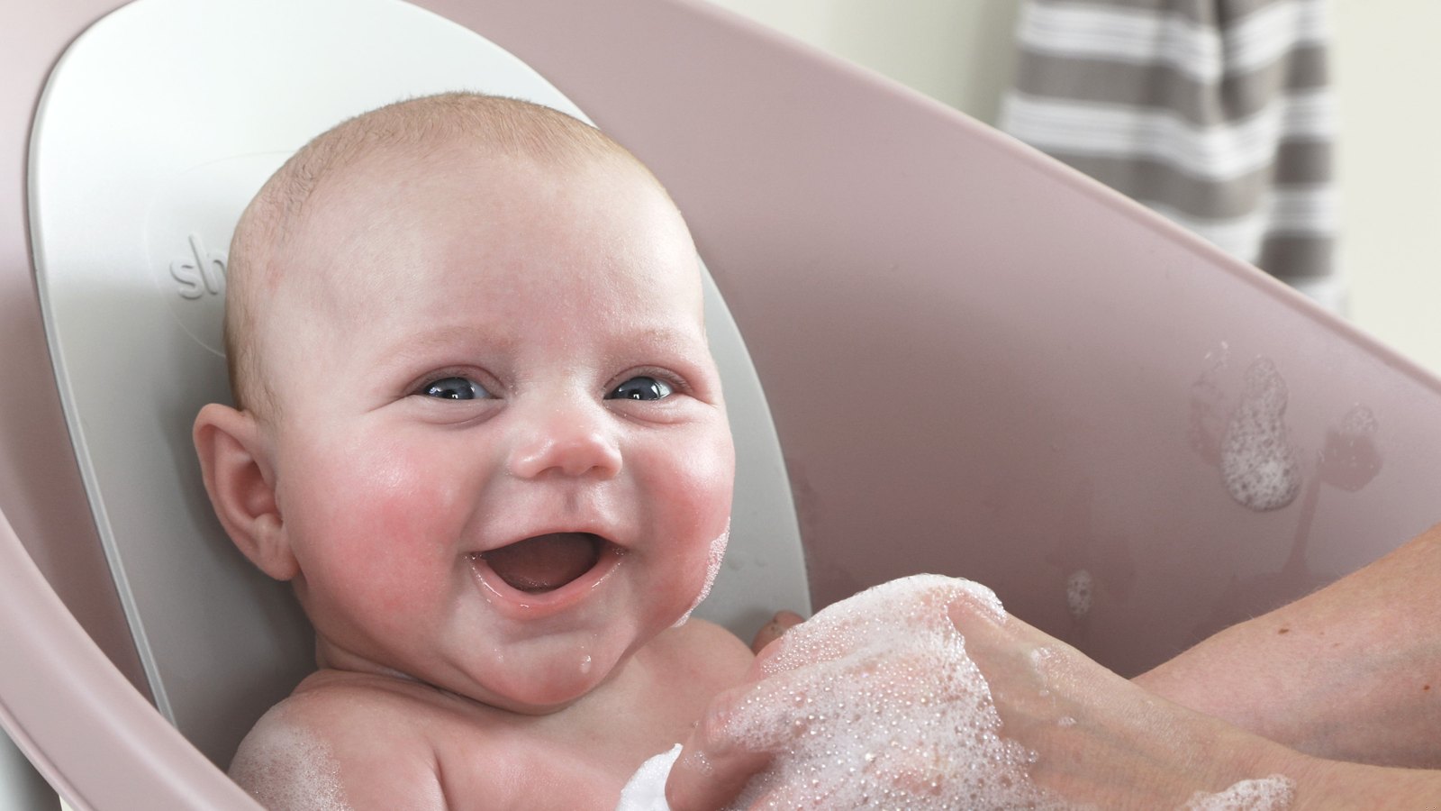 Smiling baby in a baby bathtub