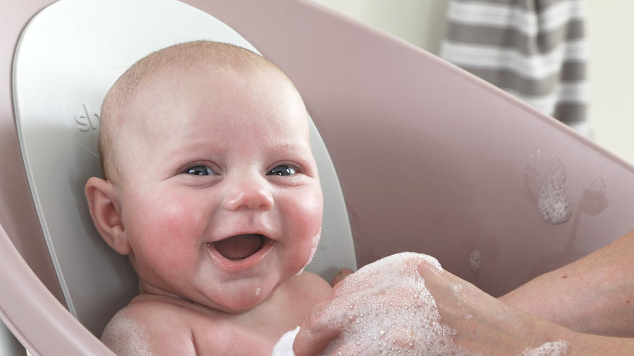 Smiling baby in a baby bathtub