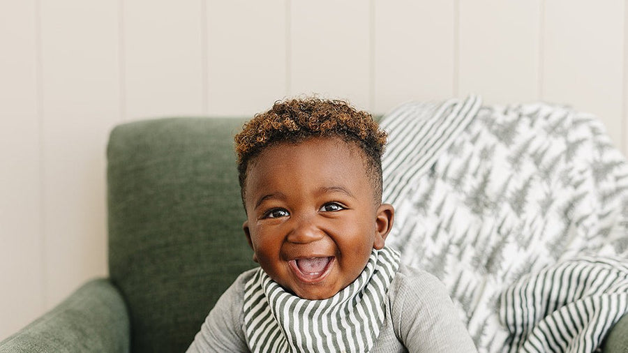 Smiling baby wearing a bandana bib