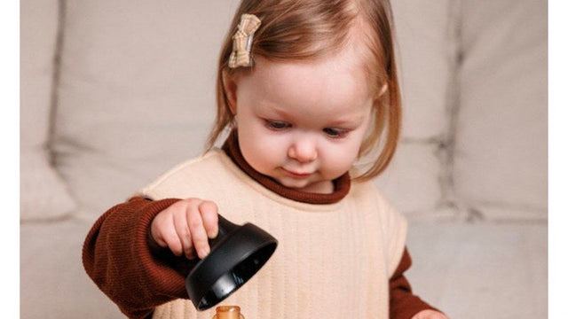 Toddler holding a baby bottle