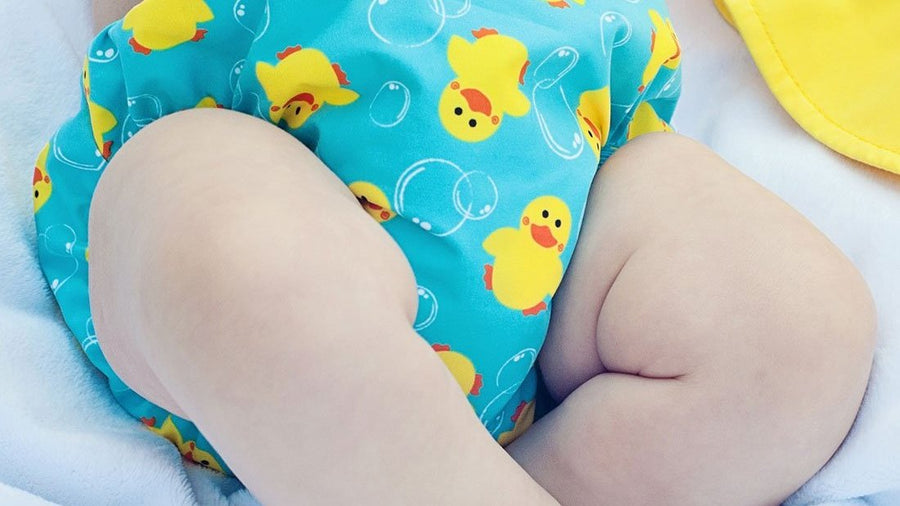 Baby wearing a duck-print reusable swim diaper