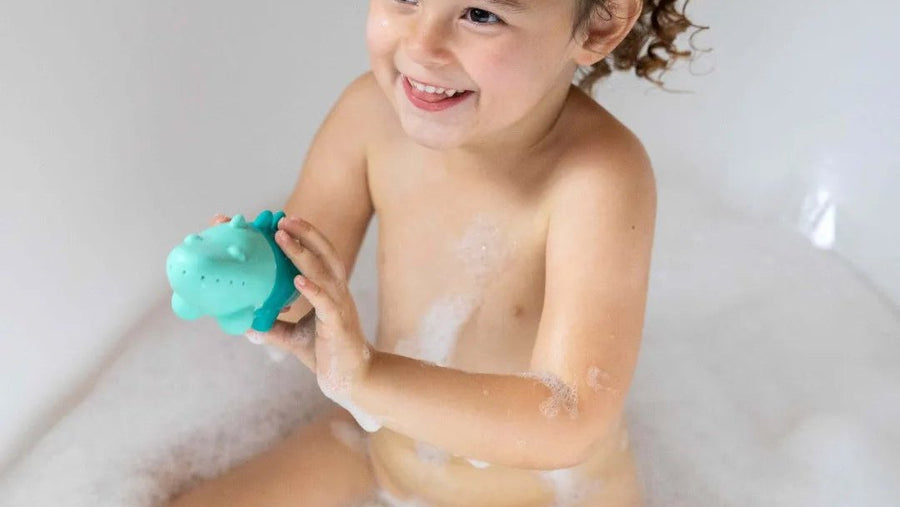 Toddler playing with bath toys in a bubble bath