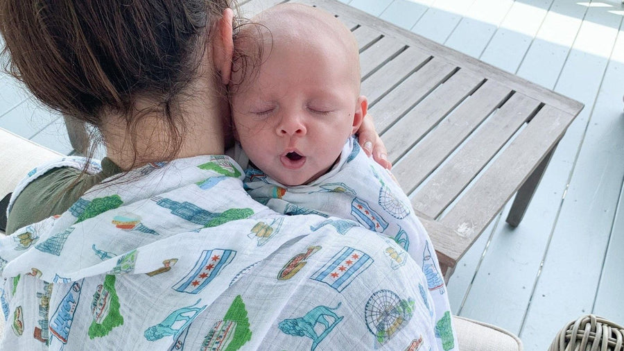 Mother holding her swaddled newborn baby