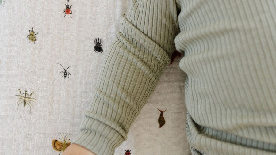 Baby lying on a soft printed crib sheet