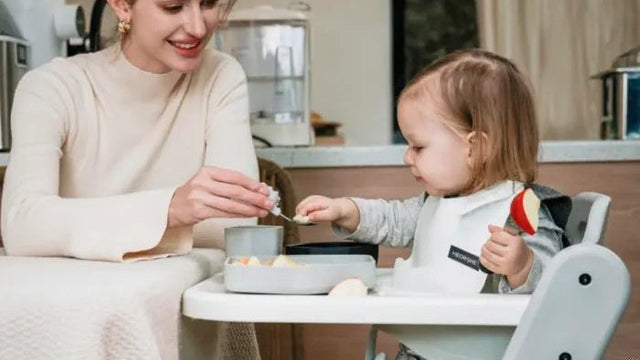 Baby being fed in a high chair