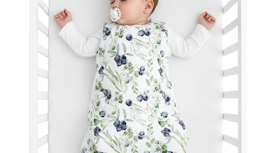 Baby wearing a sleep sack in a crib