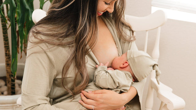 Mother feeding her newborn in a nursery chair wearing a soft robe