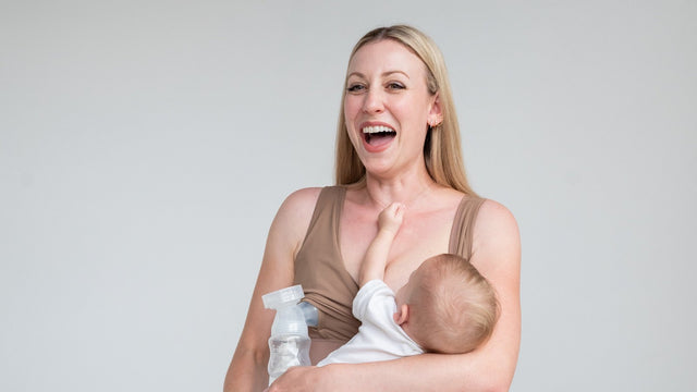 Mom laughing while nursing her baby in a Love & Fit Everyday Luxe nursing and hands-free pumping bra