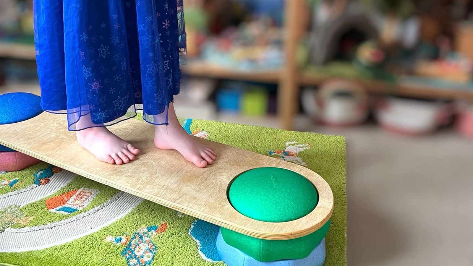 Child balancing on a Green Elephant connector board bridged across stepping stones in a playroom