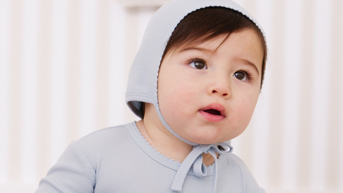 Baby in a KIPP Collection blue knit bonnet and ribbed top - KIPP Collection review 2026