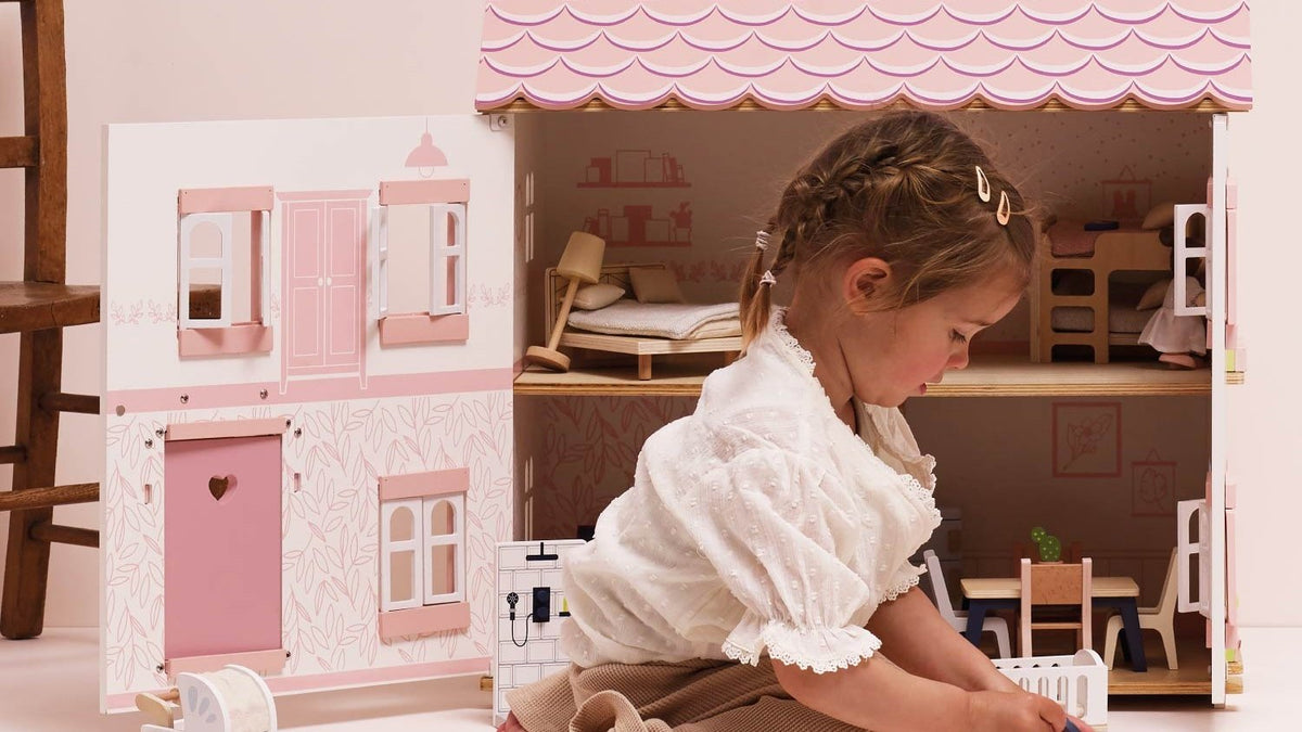Little girl playing with the Le Toy Van Sophie's wooden dollhouse