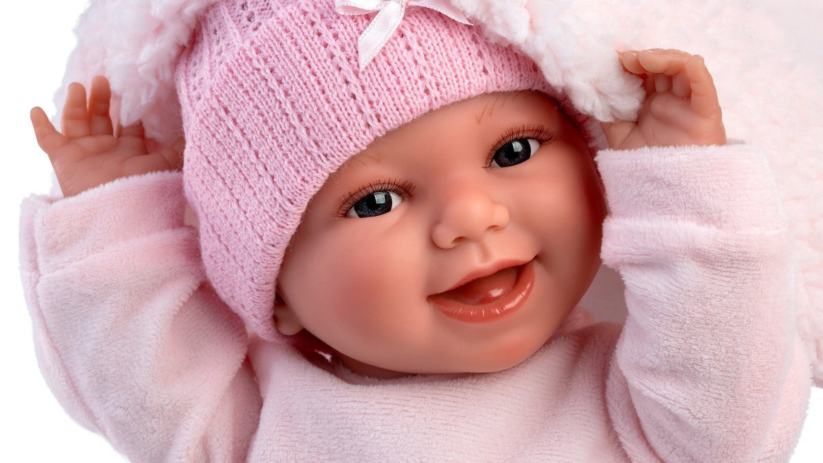 Llorens soft body newborn doll Willa smiling in a pink knit hat, one of the Spanish-made baby dolls reviewed in this guide
