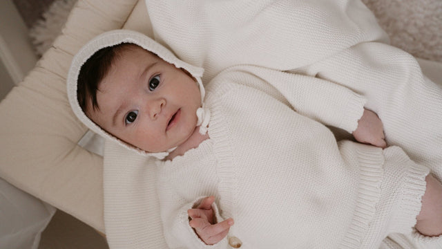 Newborn in a Luna + Luca Bring Me Home organic cotton knit bundle with bonnet