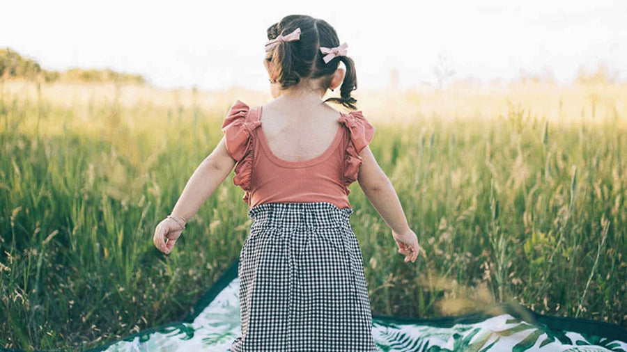 Child walking in a green field