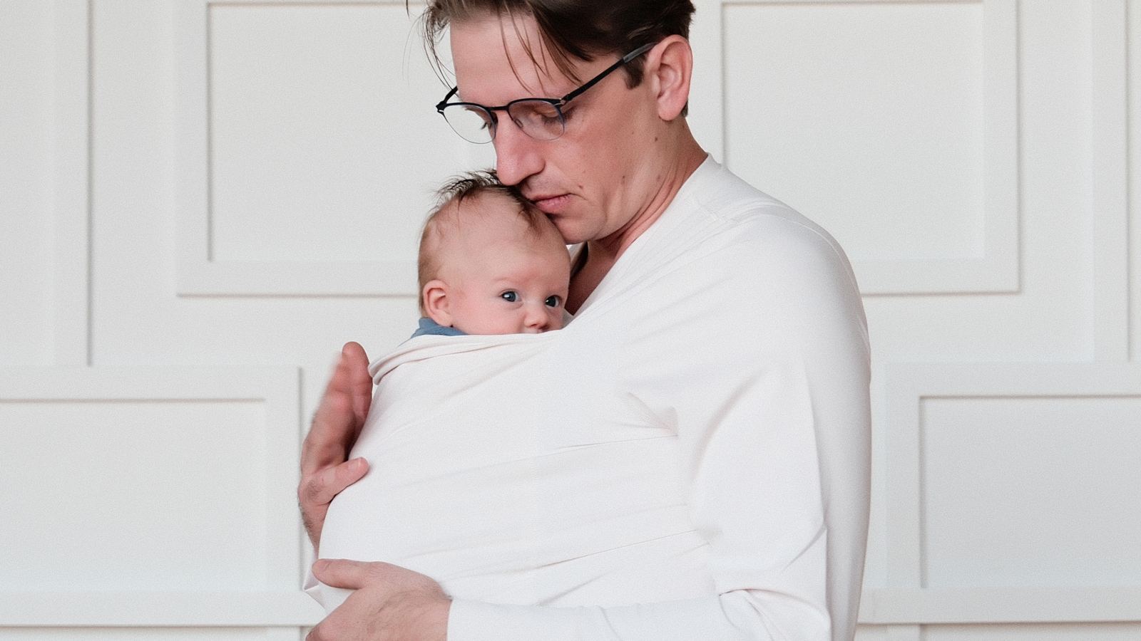 Dad in a Dad shirt holding his newborn